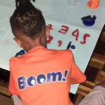 Child in a boom t-shirt painting