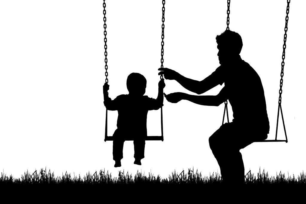 Child playing with dad on a swing silhouette