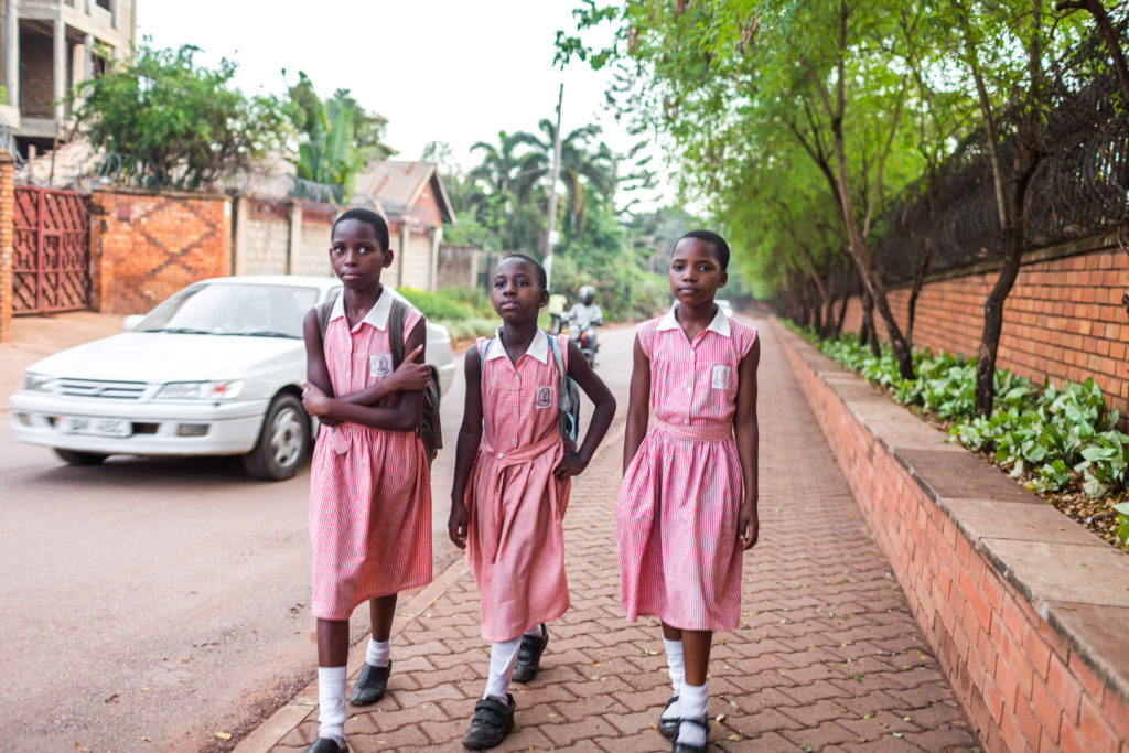Three African girls walking in school uniforms